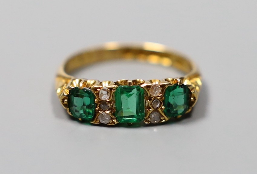 An Edwardian 18ct gold, thee stone green doublet and rose cut diamond chip set half hoop ring, size O, gross 4 grams.